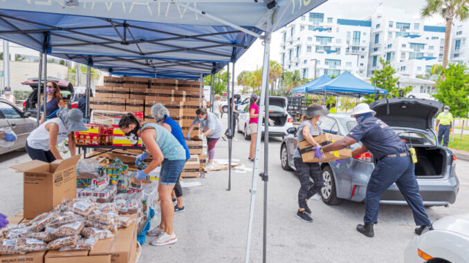 Florida, Miami Beach, Farm Share food distribution event during Coronavirus Pandemic, cars lined up and volunteers