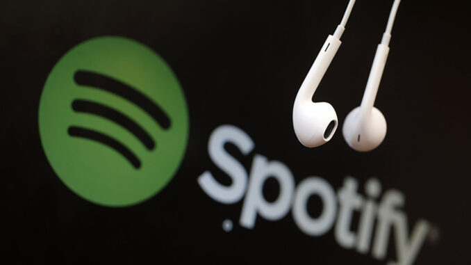 Headphones are seen in front of a logo of online music streaming service Spotify in this illustration picture